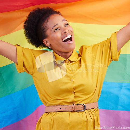 Image of Pride, flag and happy black woman in studio for gay, rights and lgbtq life or choice. Rainbow, freedom and lesbian African female celebrating, smile and confident with inclusion and support