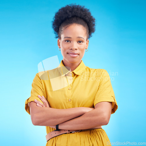 Image of Arms crossed, portrait and a black woman in studio with fashion, confidence and a positive mindset. Pride, smile and african female model person in casual clothes on a blue background for motivation