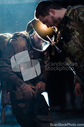 Image of Modern warfare soldiers in dark with combat ammunition and weapons in the hands of equipped laser sights are in battle order. Mixed media.