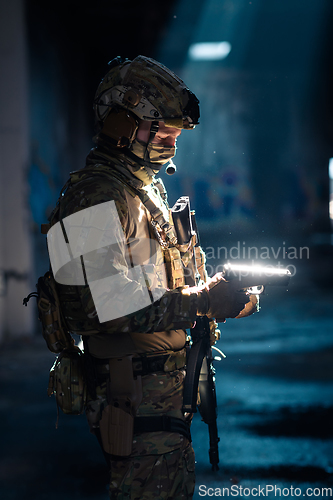 Image of A special forces soldier reloads his pistol as he prepares for a military operation