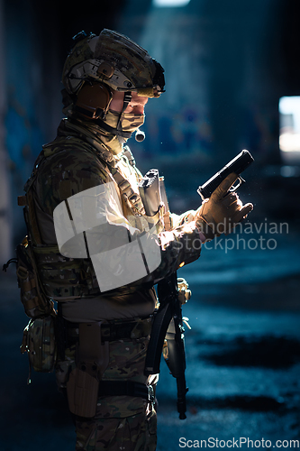 Image of A special forces soldier reloads his pistol as he prepares for a military operation