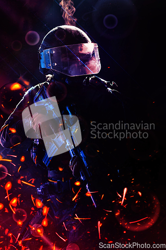 Image of Army soldier in Combat Uniforms with an assault rifle and combat helmet night mission dark background. Blue and purple gel light effect.