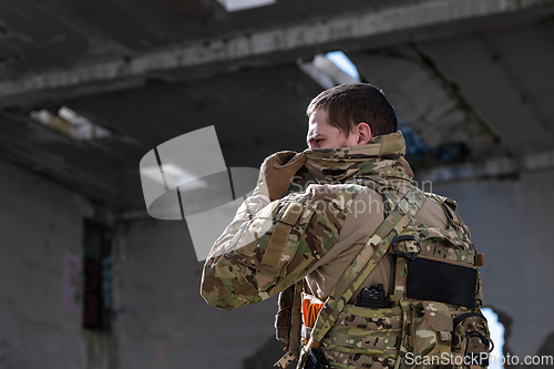 Image of Army soldier in Combat Uniforms with an assault rifle and face protection mask.