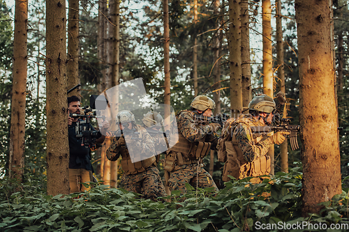 Image of Videographer with Professional Movie Video Camera Gimbal Stabilizing Equipment Taking Action Shoot of Soldiers in Action in Forest