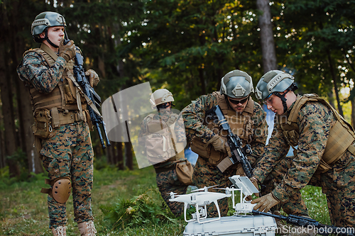 Image of Modern Warfare Soldiers Squad are Using Drone for Scouting and Surveillance During Military Operation in the Forest.