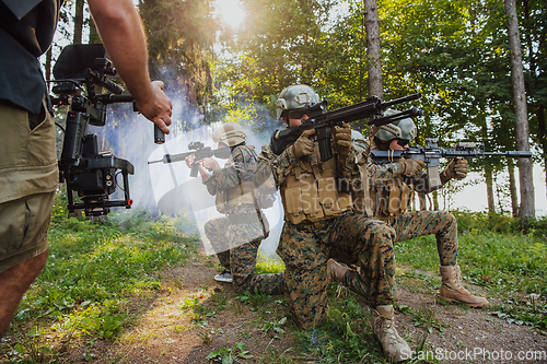 Image of Videographer with Professional Movie Video Camera Gimbal Stabilizing Equipment Taking Action Shoot of Soldiers in Action in Forest