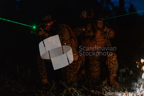 Image of Soldiers squad in action on night mission using laser sight beam lights military team concept