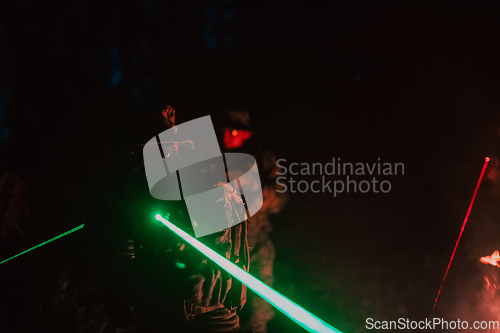 Image of Soldiers squad in action on night mission using laser sight beam lights military team concept