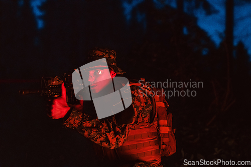 Image of Soldiers squad in action on night mission using laser sight beam lights military team concept