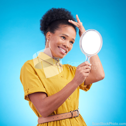 Image of Happy, beauty and a woman with a mirror in studio for hair care, confidence and appearance. Fashion, makeup and cosmetics of African female model person in casual style clothes on a blue background