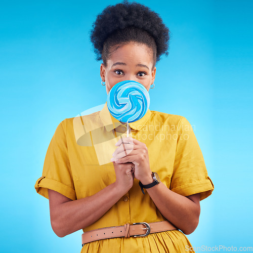 Image of Happy, candy and portrait of a black woman on a studio background for a lollipop, excited and eating. Freedom, young and an African girl or model with sweets for a snack isolated on a backdrop