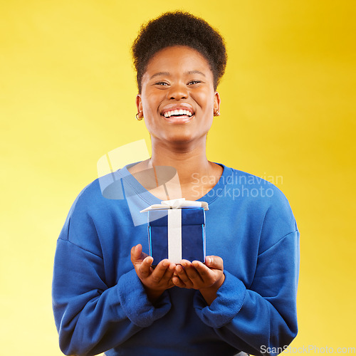 Image of Gift, birthday and portrait of black woman with a surprise happy isolated in a yellow studio background with a present. Winning, box and excited person to celebrate, party and holiday as a winner