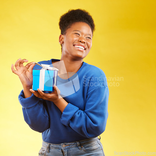 Image of Gift, winning and happy black woman with a surprise isolated in a yellow studio background for a birthday. Giveaway, box and excited person to celebrate, party and holiday as a winner with happiness