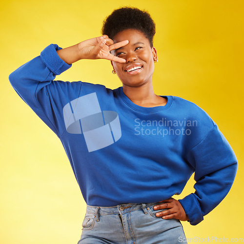 Image of Hand sign, peace and a black woman in studio with a smile, confidence and a positive mindset. Emoji, icon and happy african female model person on yellow background with a v symbol and freedom