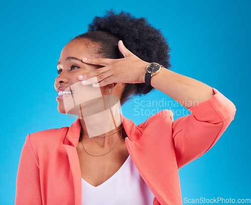 Image of Fashion, smile and a model black woman on a blue background in studio posing in a suit for style. Face, clothes and a happy young female person standing in a trendy outfit for a magazine cover