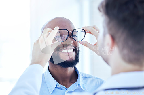 Image of Smile, African man and optometrist with glasses for eye support and lens check at a doctor consultation. Medical, wellness and patient with vision and eyewear care with professional holding frame