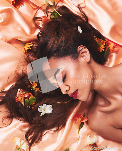 Image of Hair, silk and flowers by a woman with beauty and cosmetic fashion fabric for wellness, glow and skincare. Aesthetic, above and calm young female person with luxury, natural or elegant backdrop