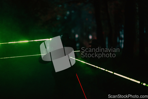 Image of Soldiers squad in action on night mission using laser sight beam lights military team concept