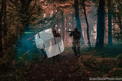 Image of Soldiers squad in action on night mission using laser sight beam lights military team concept