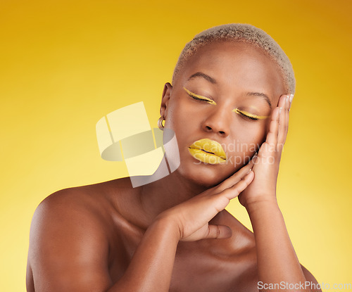 Image of Face, creative makeup and lipstick with a black woman in studio on a yellow background for beauty, art or cosmetics. Gold, color and eyeshadow on young model with eyes closed and unique aesthetic