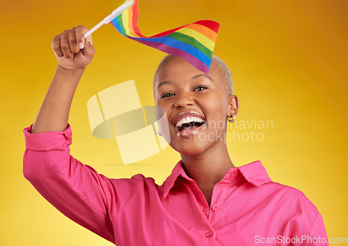 Image of Flag, pride and portrait of black woman with support of the lgbtq community isolated in a studio yellow background. Smile, happy and gen z or young gay person with rainbow symbol of equality