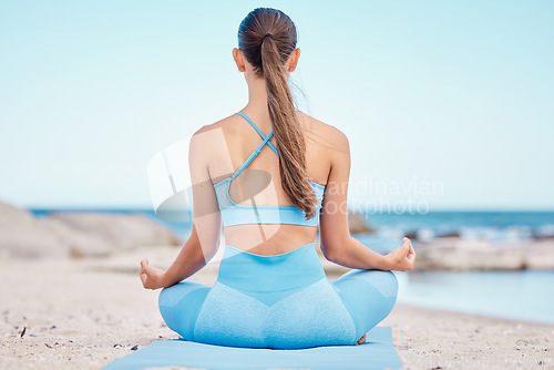 Image of Yoga, meditation and back view of woman at the beach for workout or training as health, mindfulness and wellness routine. Healthy, body and person exercise a chakra by doing lotus pose at sea