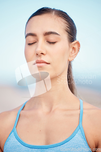 Image of Calm, fitness and woman at beach for meditation, training the mind and exercise for zen. Yoga, nature and face of a young girl with peace during a wellness and spiritual workout at the sea to relax