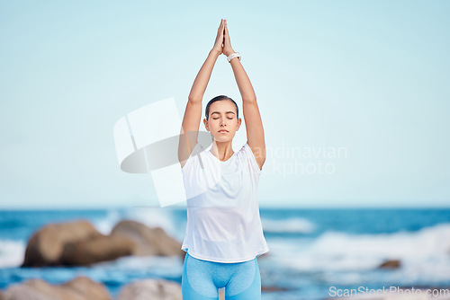 Image of Yoga, fitness and woman at the beach for workout or training as health, mindfulness and wellness routine. Healthy, body and person exercise a chakra by doing tree pose at the sea or in nature