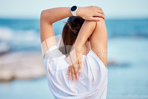 Image of Woman, fitness and back on beach in stretching, workout or getting ready for exercise or outdoor training. Rear view of sports female person in body warm up, preparation or healthy wellness by ocean