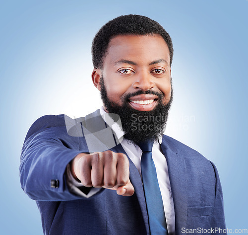 Image of Portrait, motivation and fist with a business black man in studio on a blue background for trust or support. Leadership, smile and confident with a happy male CEO or manager in a professional suit