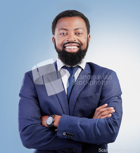 Image of Happy, crossed arms and portrait of businessman in a studio with success, confidence and leadership. Smile, professional and headshot of a young, smart and African lawyer isolated by blue background.