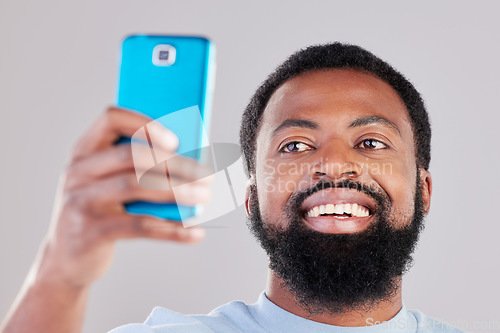 Image of Happy black man, face and selfie in photography for social media, vlog or networking against a grey studio background. African male person smile for photo, memory or online communication and picture