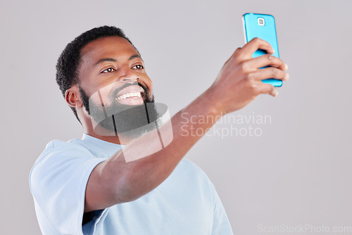 Image of Happy black man, selfie and photography for social media, vlog or networking against a grey studio background. African male person smile for photo, memory or online communication and picture post