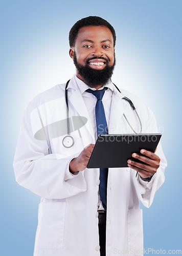 Image of Healthcare, portrait and tablet and a black man doctor in studio on a blue background for cardiology research. Medical, innovation and a male medicine professional searching for information online