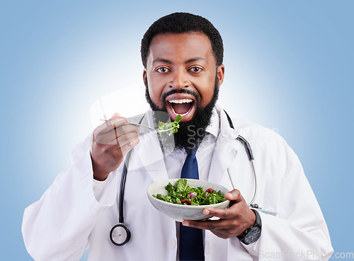 Image of Doctor studio portrait, black man and salad to lose weight, vegan healthcare diet or healthy food benefits for clean eating. Green lettuce bowl, hungry or African male nutritionist on blue background