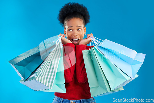 Image of African woman, shopping bag or thinking in studio with wow, discount or sale by blue background. Gen z girl, student and shock with retail addiction, doubt or ideas for commercial customer experience