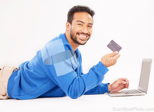 Image of Online shopping, laptop and portrait man smile for credit card discount, fintech service or ecommerce sale. Studio customer, savings transfer payment or relax person banking on white background floor