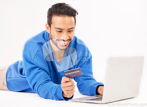 Image of Studio laptop, credit card and happy man online shopping for tech discount, promotion or e commerce sales. Customer payment, trading store and relax financial banking person on white background floor