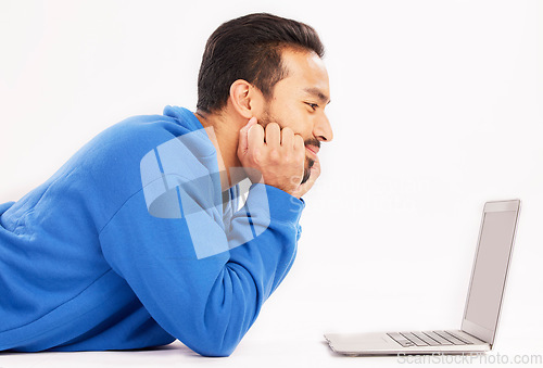 Image of Man, laptop and relax on studio floor for digital streaming, online show and download subscription. Happy asian male model watch connection on computer technology, internet news and white background