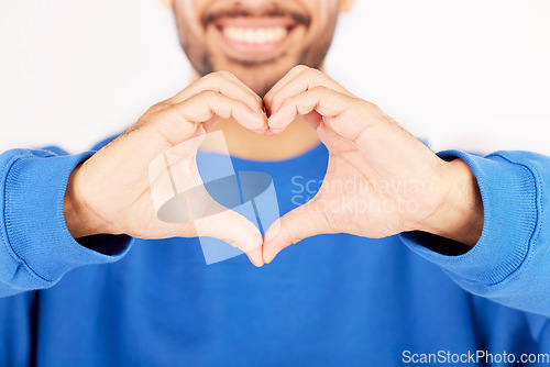 Image of Closeup, heart and hands of man in studio, white background and care for kindness, donation and charity. Happy model with finger shape for love icon, thank you and emoji in support of valentines day