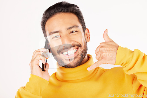 Image of Man, phone call and hand sign with a smile in studio for flirting or communication portrait. Face of a happy asian person talking on a smartphone with contact us emoji isolated on a white background