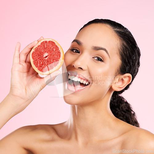 Image of Grapefruit, beauty and face of happy woman with skin care, dermatology or natural glow. Portrait of a female model with fruit for vitamin c, cosmetics or healthy diet for detox on studio background