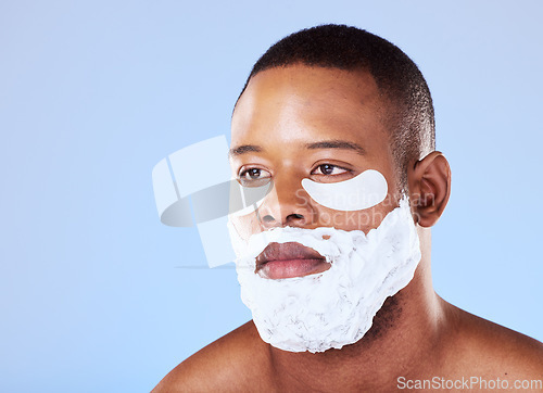 Image of Skincare, black man and eye mask while shaving in studio cleaning, cosmetic or treatment on blue background. Face, beauty and African guy model with gel patch and skin for facial, hair or wellness