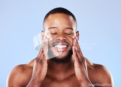 Image of Beauty, skincare and cream on face of black man in studio for sunscreen, cosmetics and spa treatment. Facial, self care and dermatology with person on blue background for lotion, wellness and health
