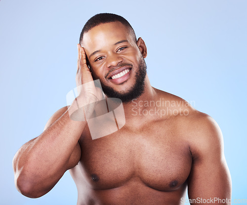 Image of Happy, skincare and portrait of a black man with a glow on a blue background from dermatology. Smile, touching and an African person or model with facial wellness, health and cleaning for beauty