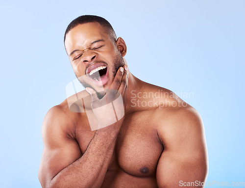 Image of Tired, yawning and a black man with skincare on a blue background for beauty and wellness. Health, model and an African person or model with fatigue isolated on a studio backdrop for wellbeing