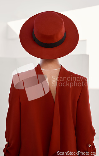Image of Vintage, fashion and person with red hat and white background in studio for creative, designer and retro clothing. Mystery, couture model and person in a suit with beauty, aesthetic or character