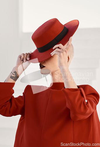 Image of Woman, red hat and mystery with fashion, makeup and beauty with aesthetic, vintage style or character. Girl, model and retro clothes with cosmetics, art and hidden face with suit with creativity