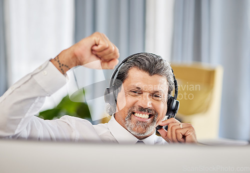 Image of Call centre, celebrate and a happy man at a computer with success, achievement or bonus win. Mature male consultant or agent with fist for customer service, help desk and crm or telemarketing target