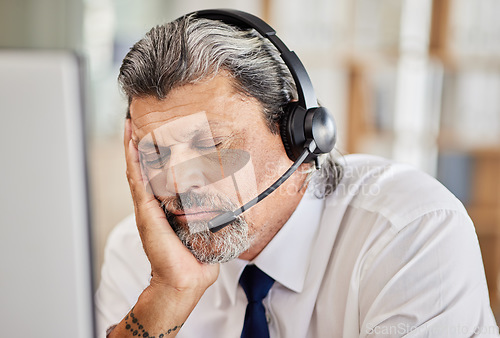 Image of Tired, call center and male consultant sleeping in his office while doing an online consultation. Exhausted, burnout and mature man telemarketing or customer support agent with a headset in workplace